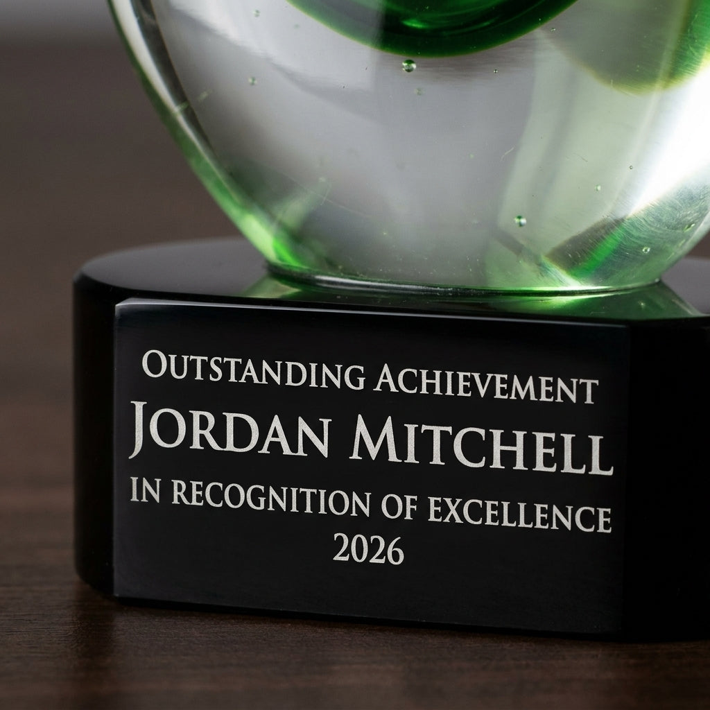 Close-up of the custom laser engraving on a personalized Green art glass award, showing crisp permanent personalization