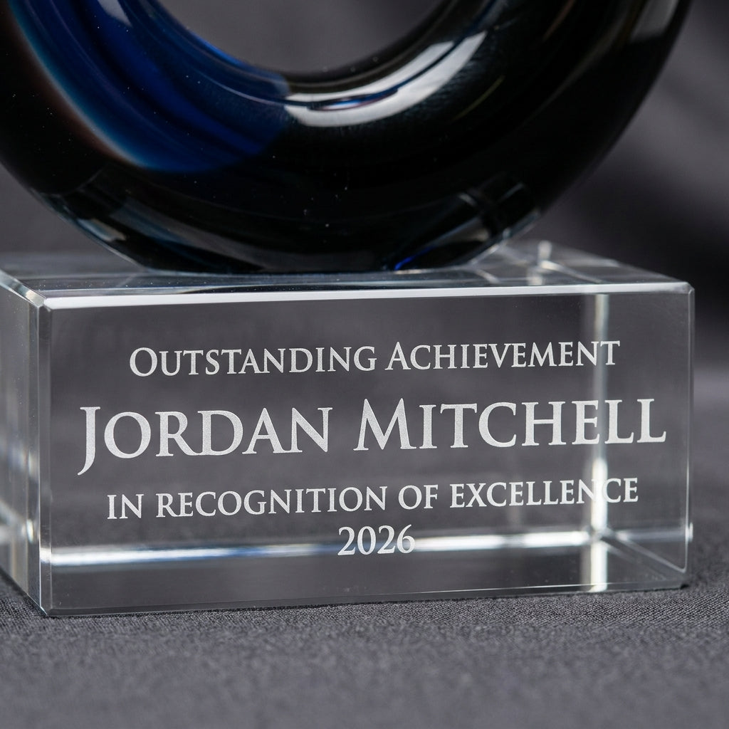 Close-up of the custom laser engraving on a personalized Black Blue Flame Knot art glass award, showing crisp permanent personalization