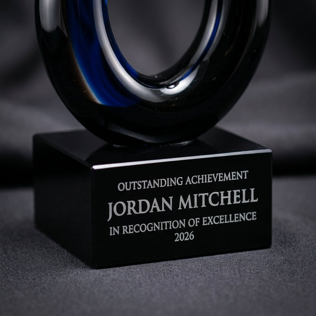 Close-up of the custom laser engraving on a personalized Sculpture art glass award, showing crisp permanent personalization