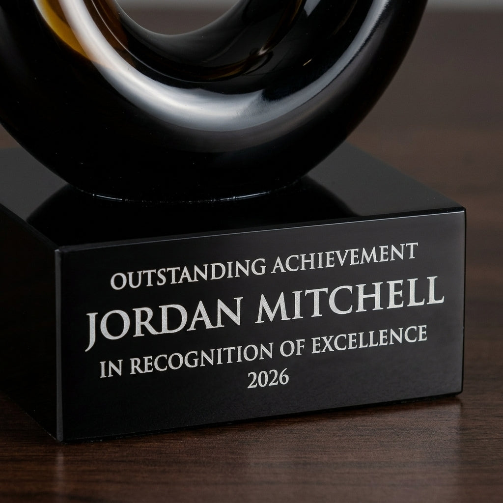 Close-up of the custom laser engraving on a personalized Sculpture art glass award, showing crisp permanent personalization