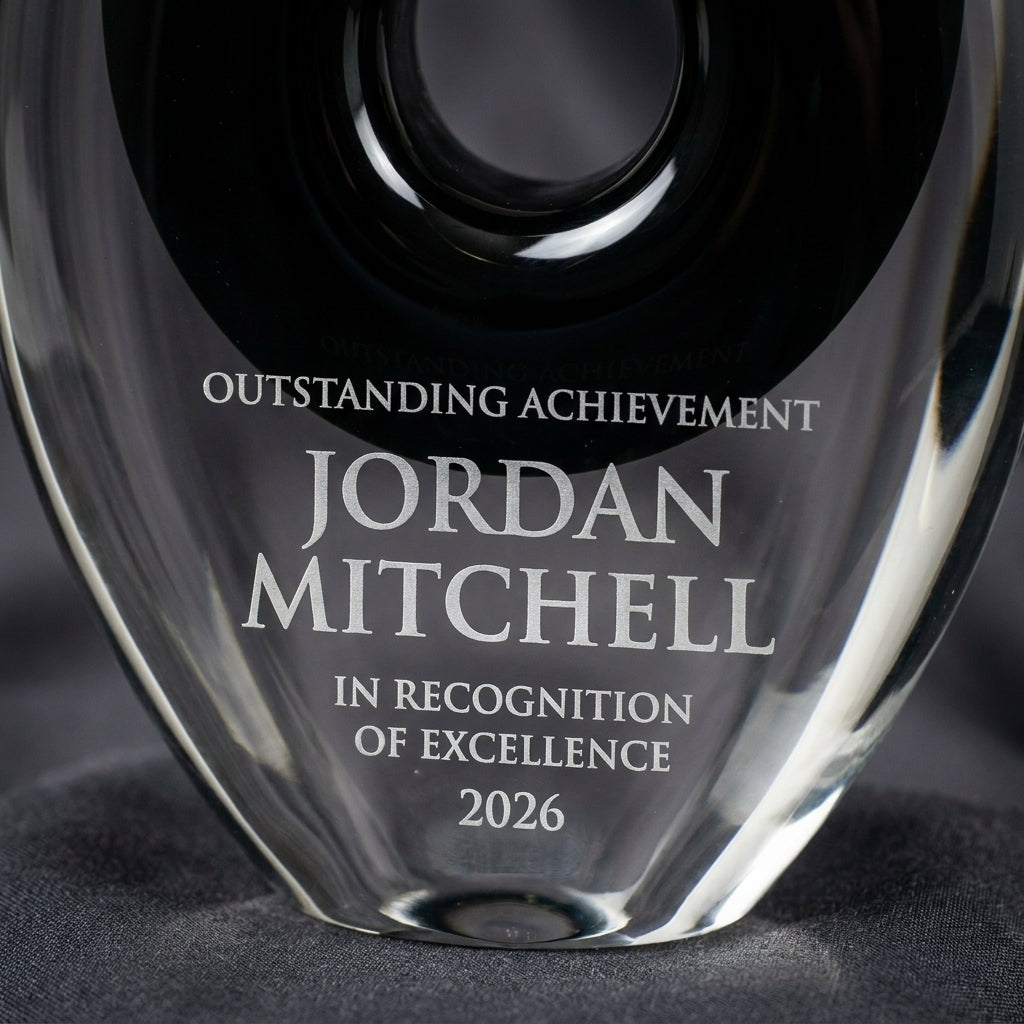 Close-up of the custom laser engraving on a personalized Black Teardrop Cutout art glass award, showing crisp permanent personalization