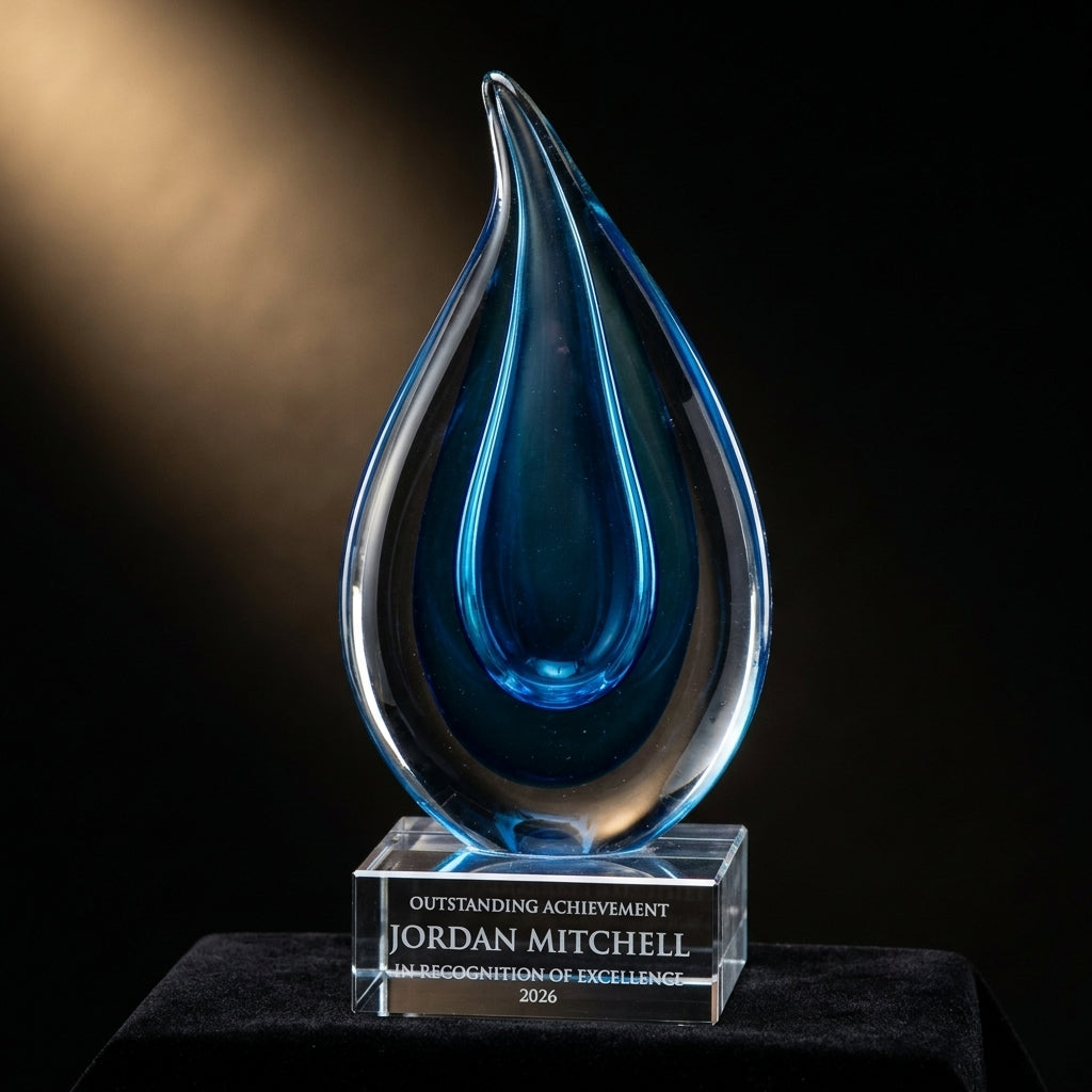 Personalized Aqua Blue Raindrop art glass award on black velvet under awards-ceremony spotlight, engraved champion and lifetime achievement award