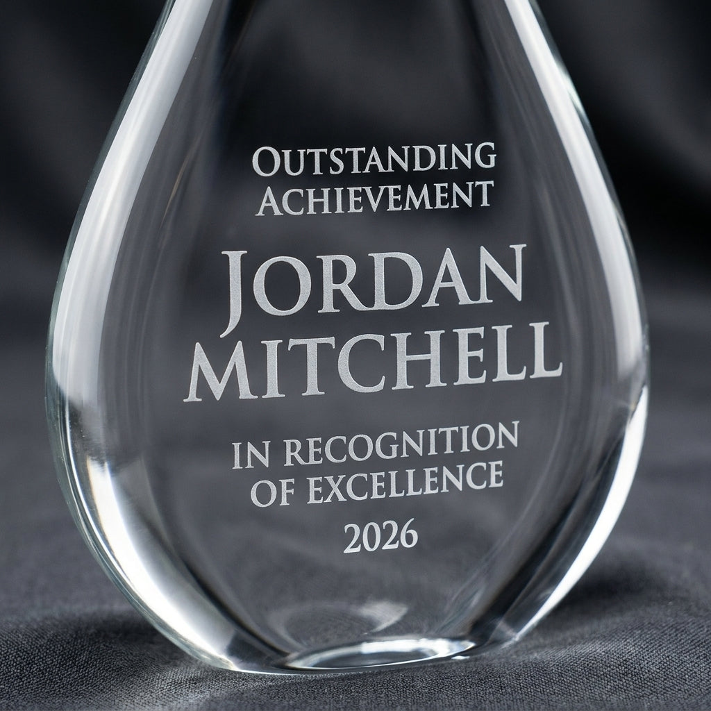 Close-up of the custom laser engraving on a personalized Sapphire Gold Raindrop art glass award, showing crisp permanent personalization