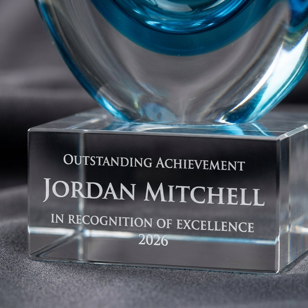 Close-up of the custom laser engraving on a personalized Sculpture art glass award, showing crisp permanent personalization