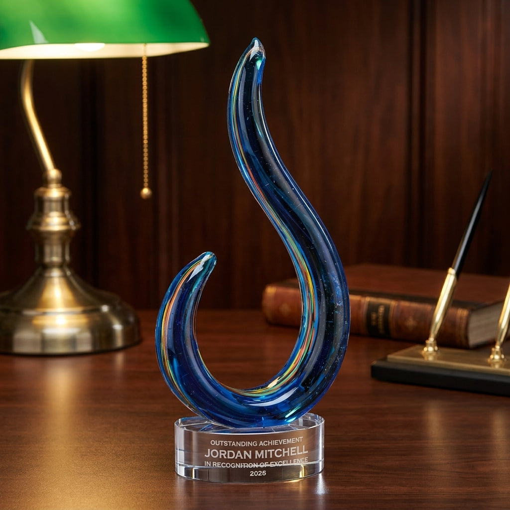 Personalized Swirl art glass award on a warm executive desk with a green banker's lamp, engraved corporate recognition and retirement gift