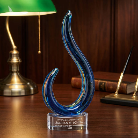 Personalized Swirl art glass award on a warm executive desk with a green banker's lamp, engraved corporate recognition and retirement gift