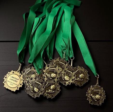 Personalized cheerleading medal in gold, silver, and bronze with custom engraved text and neck ribbon