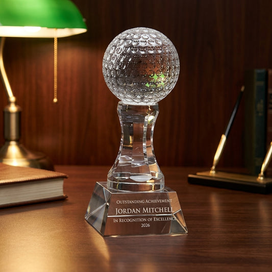 Personalized Golf Ball crystal award on a warm executive desk with a green banker's lamp, engraved corporate recognition and retirement gift