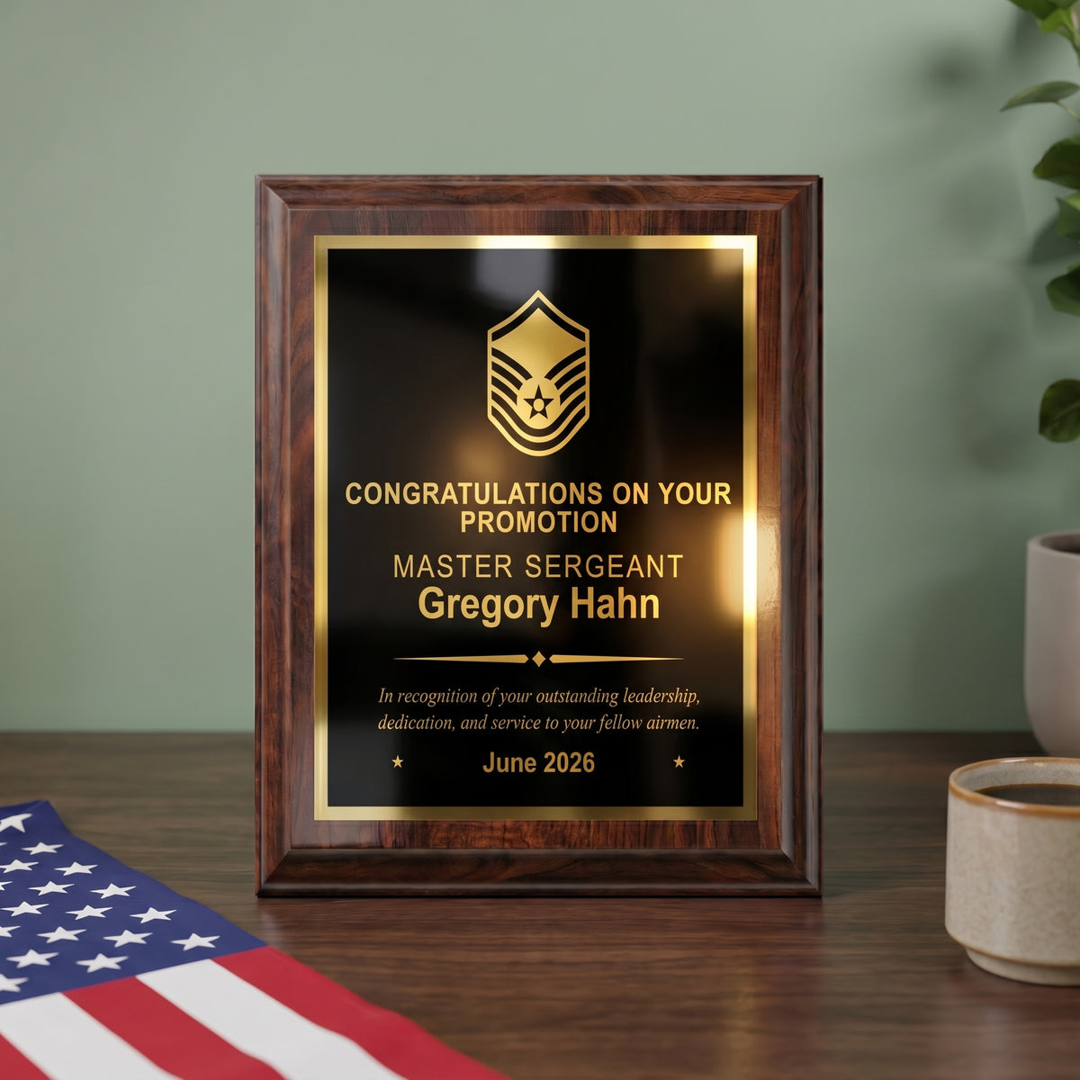 Personalized Air Force cherry plaque with a Master Sergeant insignia and name engraved in gold on a black brass plate, styled as a promotion gift on a desk