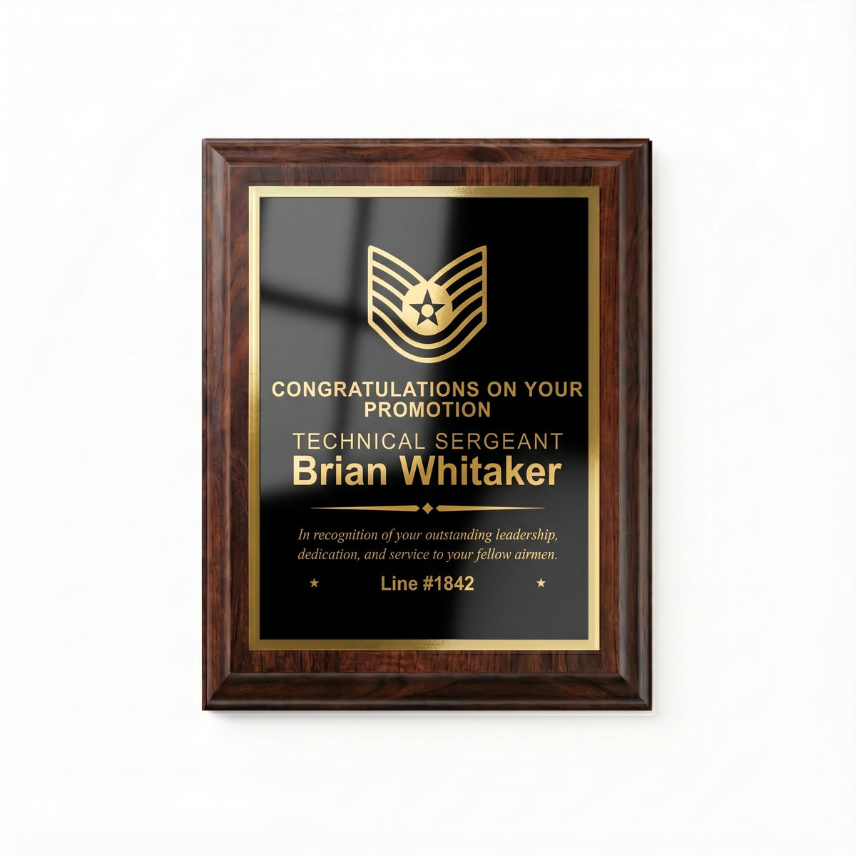 Air Force Technical Sergeant promotion plaque, straight-on view of the gold engraved insignia, name, diamond divider, message, and promotion line number with stars