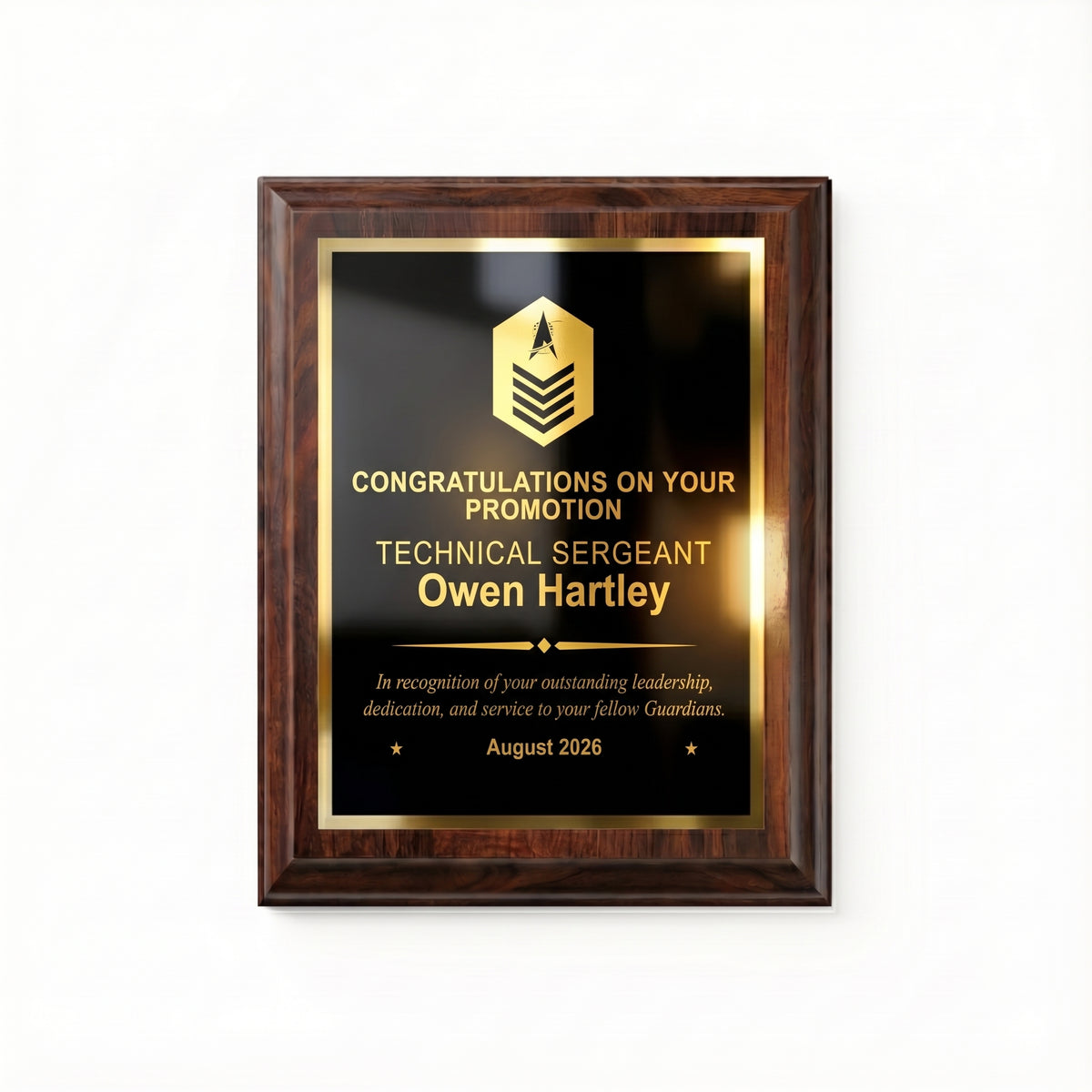 Space Force Technical Sergeant promotion plaque, straight-on view of the gold engraved rank insignia, name, diamond divider, message, and date on the black plate