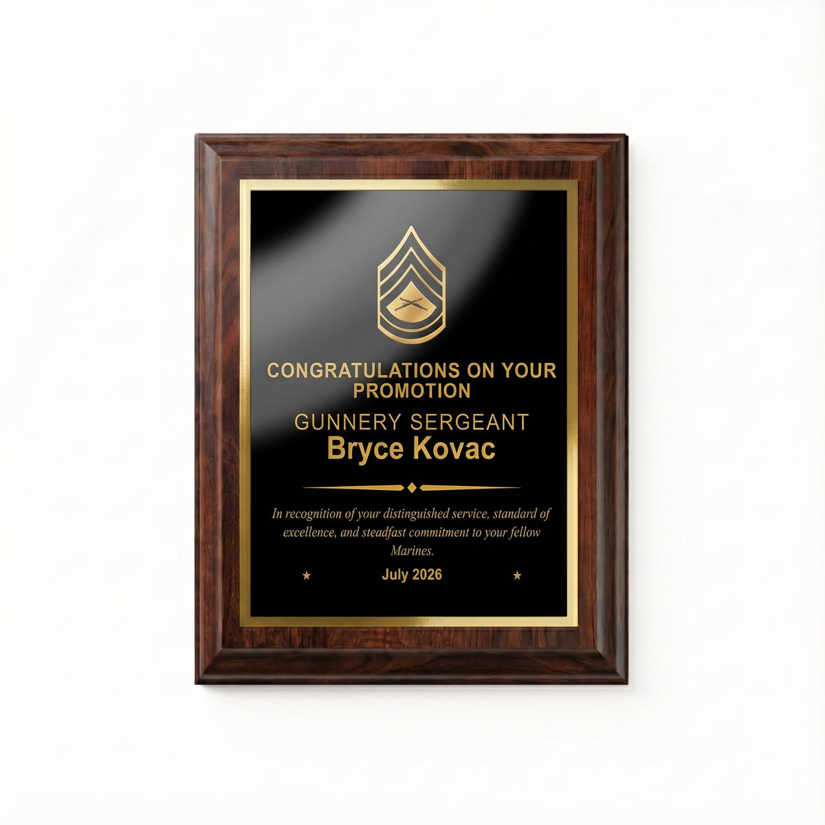 Marine Corps Gunnery Sergeant promotion plaque, straight-on view of the gold engraved rank insignia, name, diamond divider, message, and date on the black plate