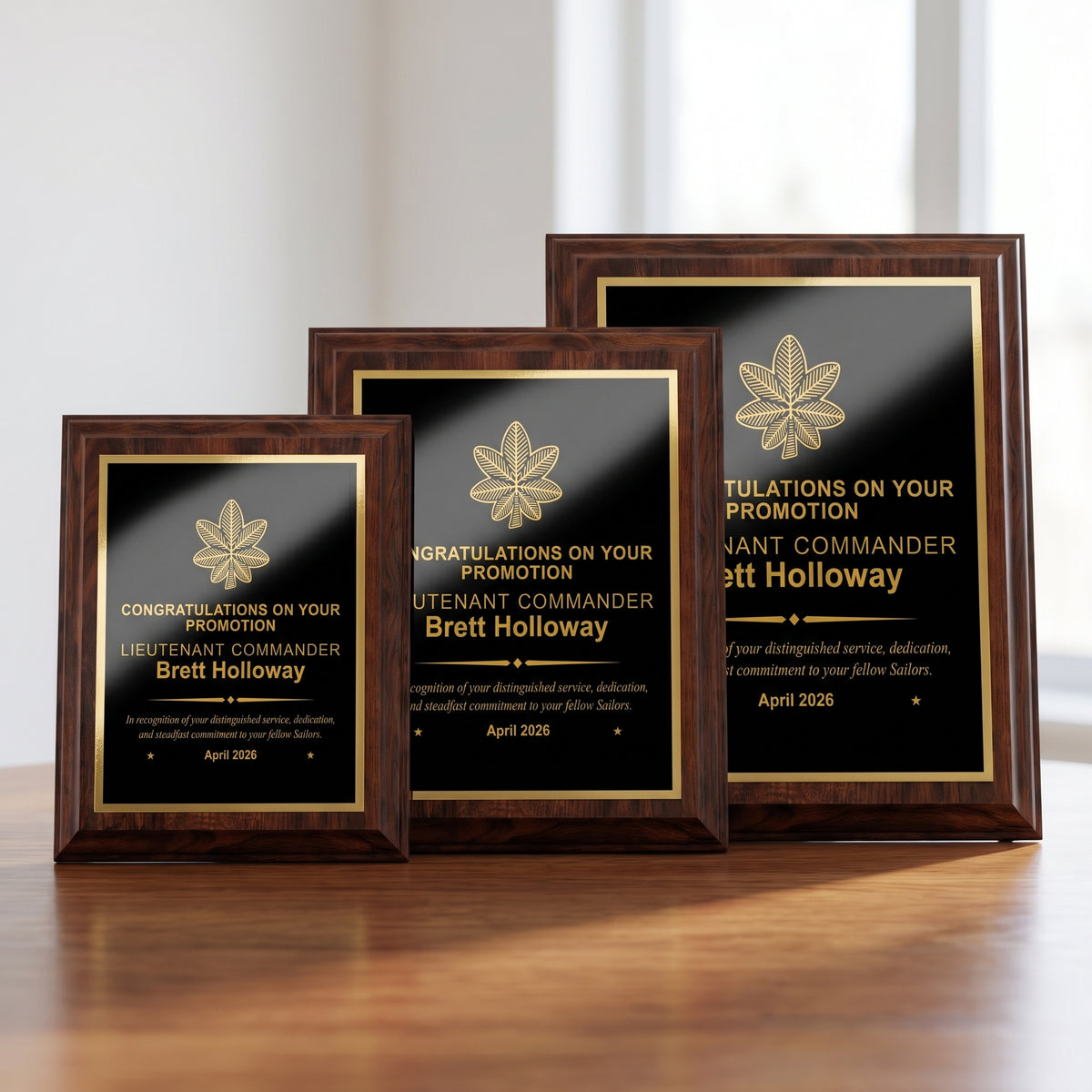 Small, medium, and large Navy cherry plaques side by side showing the engraved Lieutenant Commander insignia and name scaled to each plaque size
