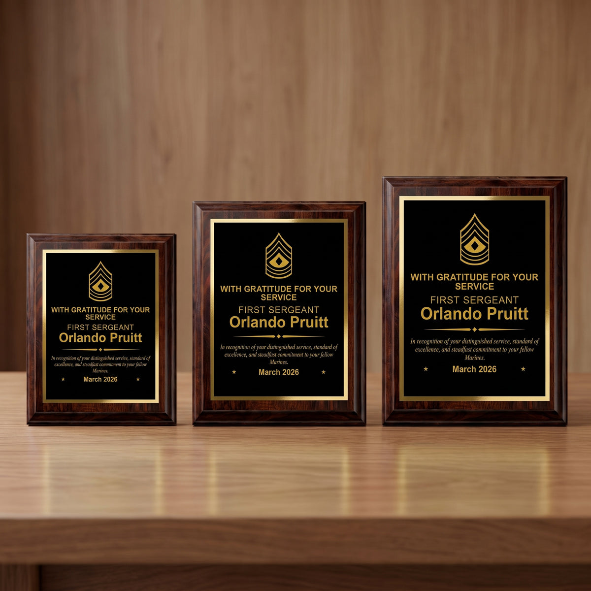 Small, medium, and large Marine Corps cherry plaques side by side showing the engraved First Sergeant insignia and name scaled to each plaque size