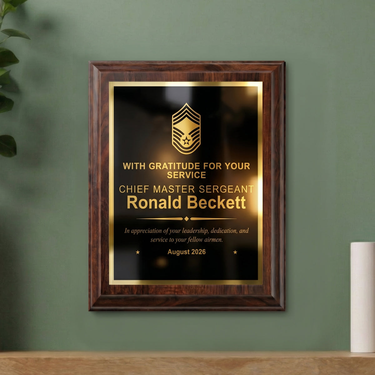 Air Force Chief Master Sergeant plaque hanging on a wall, cherry finish with the insignia, name, and gratitude message engraved in gold