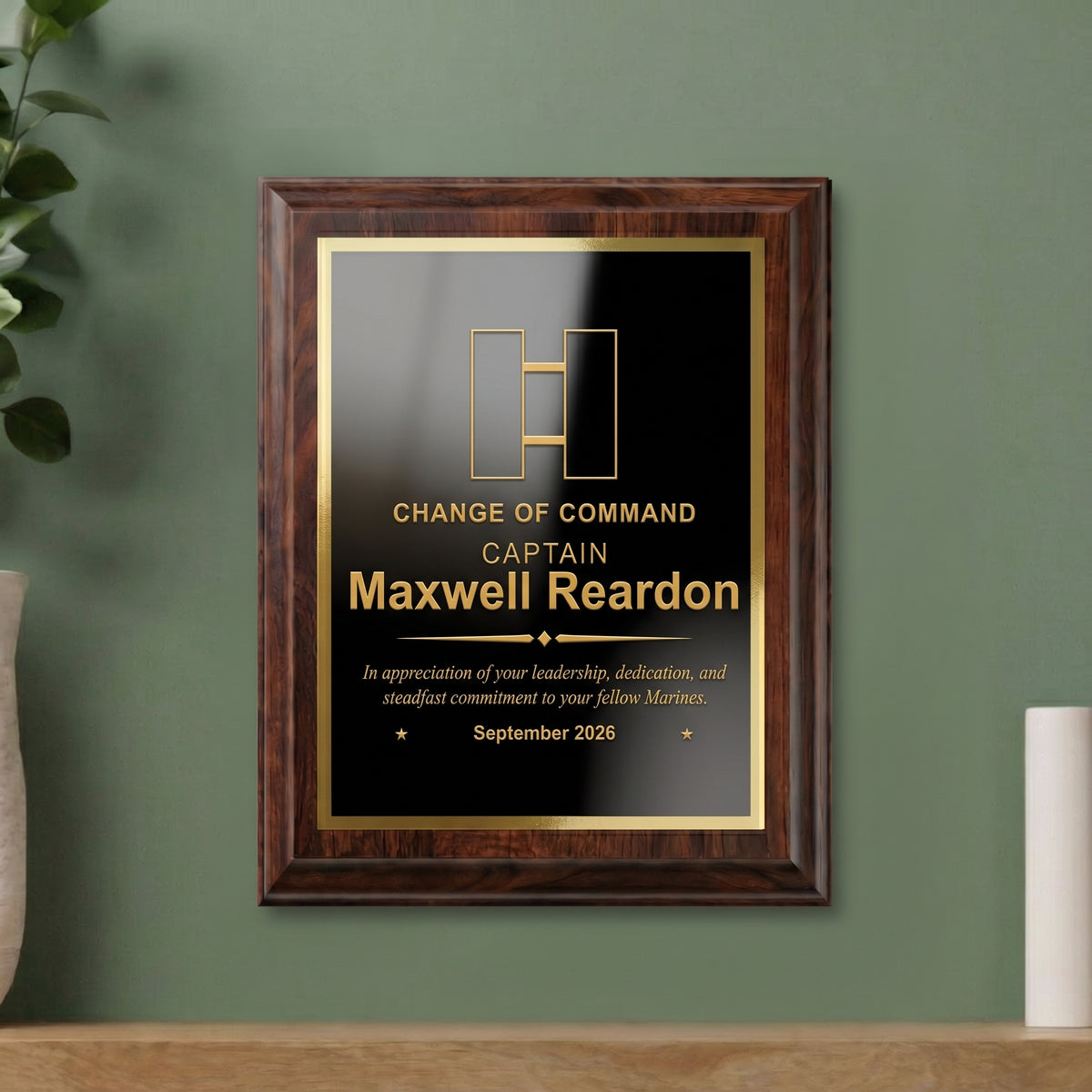 Marine Corps Captain change of command plaque hanging on a wall, cherry finish with the officer insignia, name, and date engraved in gold