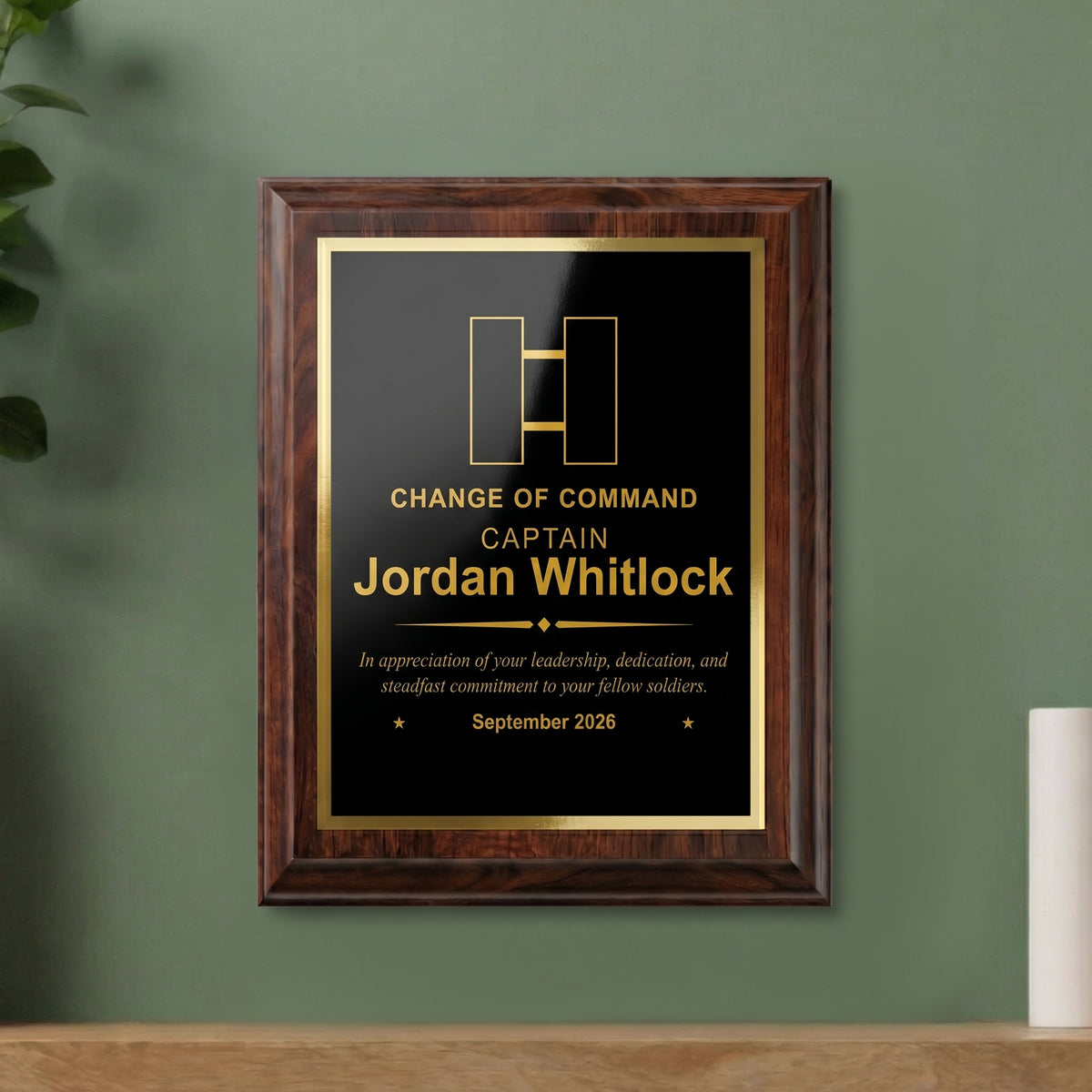 Army Captain change of command plaque hanging on a wall, cherry finish with the officer insignia, name, and date engraved in gold
