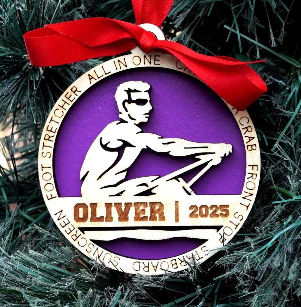 Ornament with a purple circle and white figure, hanging on a Christmas tree. Decorative ornament with a red ribbon on a Christmas tree, christmas gift for rower, christmas ornament for rowing team, rowing team gift, christmas rowing gift