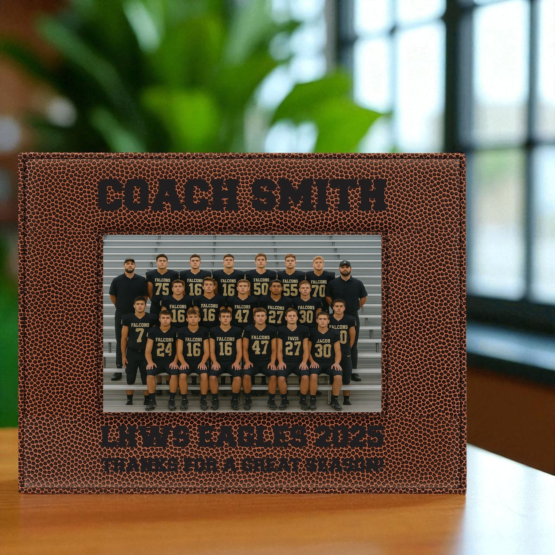 Personalized photo frame with football texture displaying a team photo and text, placed on a surface with a blurred background.