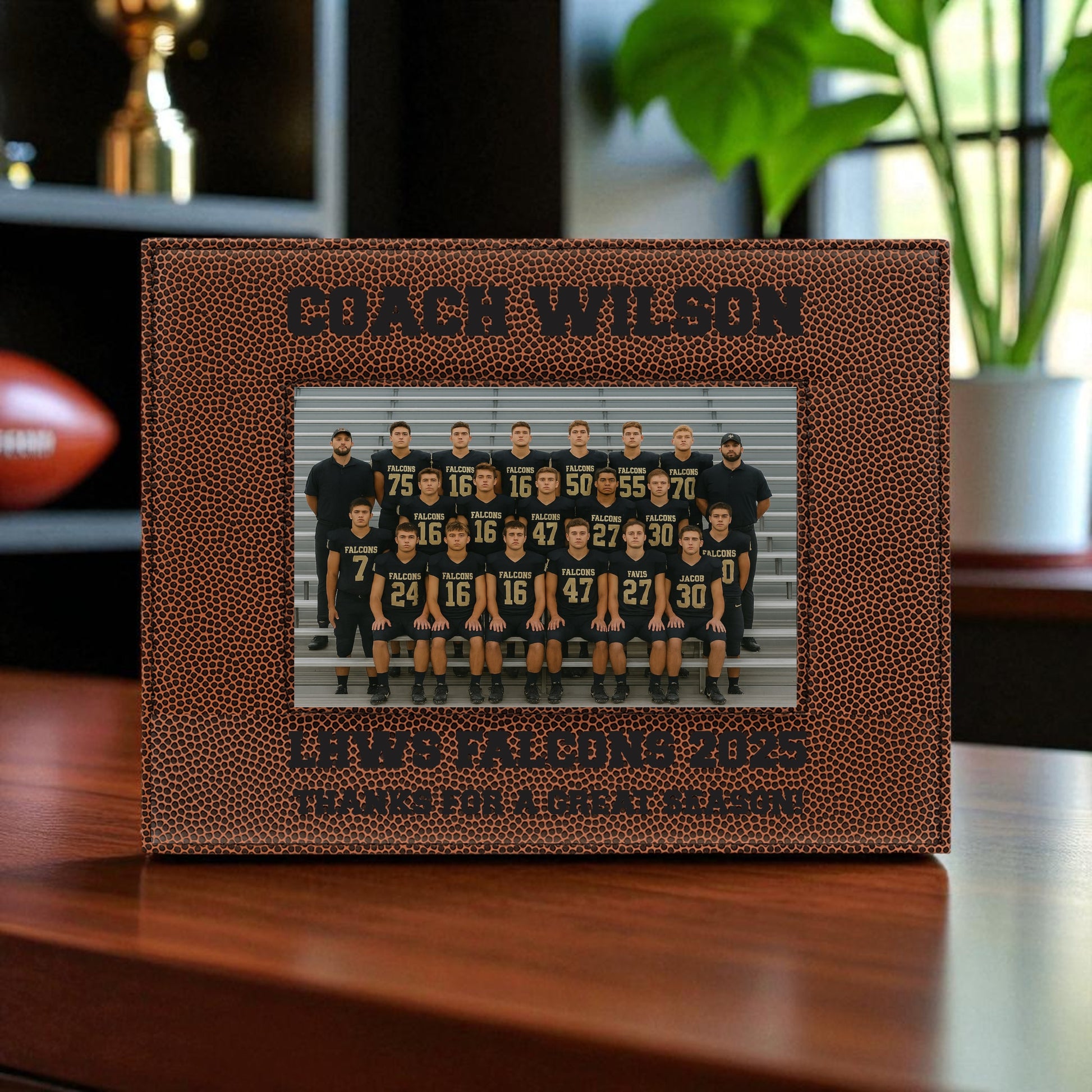 Personalized photo frame with football texture displaying a team photo, placed on a wooden surface.
